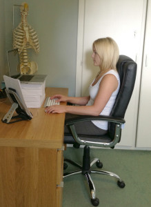 Safer: Using an external keyboard and mouse and raising the screen with paper reams improves this laptop workstation for Chiropractor Yvonne